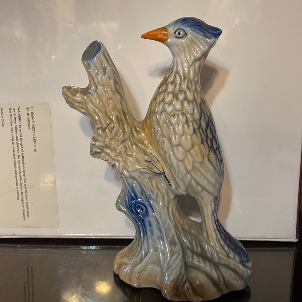 Vintage ceramic woodpecker on tree branch